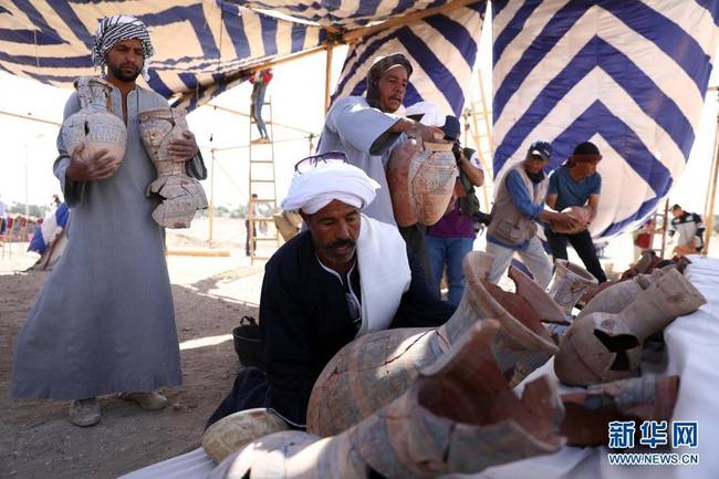 4月10日，在埃及卢克索“失落的黄金城市”遗址考古现场，工作人员搬运出土的陶器。